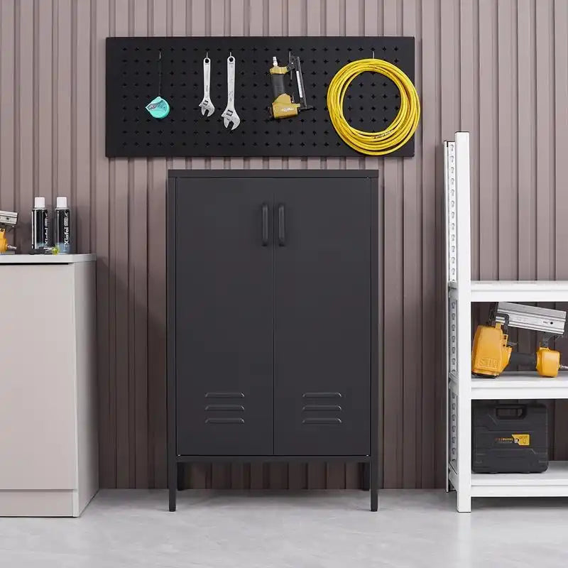 A closed black metal tool storage cabinet positioned below a wall pegboard in an organized garage setup. #black
