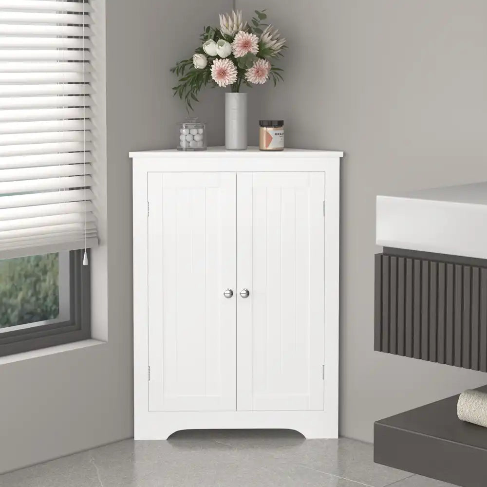 corner storage cabinet with double doors seamlessly fitted in a bathroom topped with decorative accessories