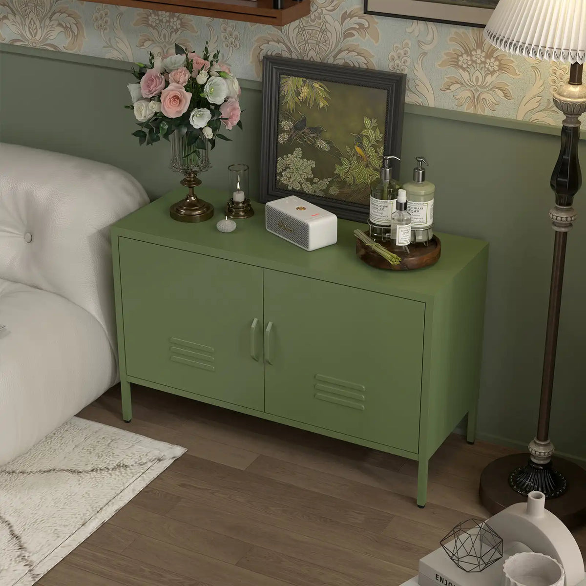 Olive green metal credenza placed beside a couch with decorative items on top.