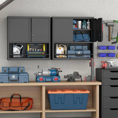 Two black wall-mounted metal cabinets installed above a wooden workbench with tools and organizers.