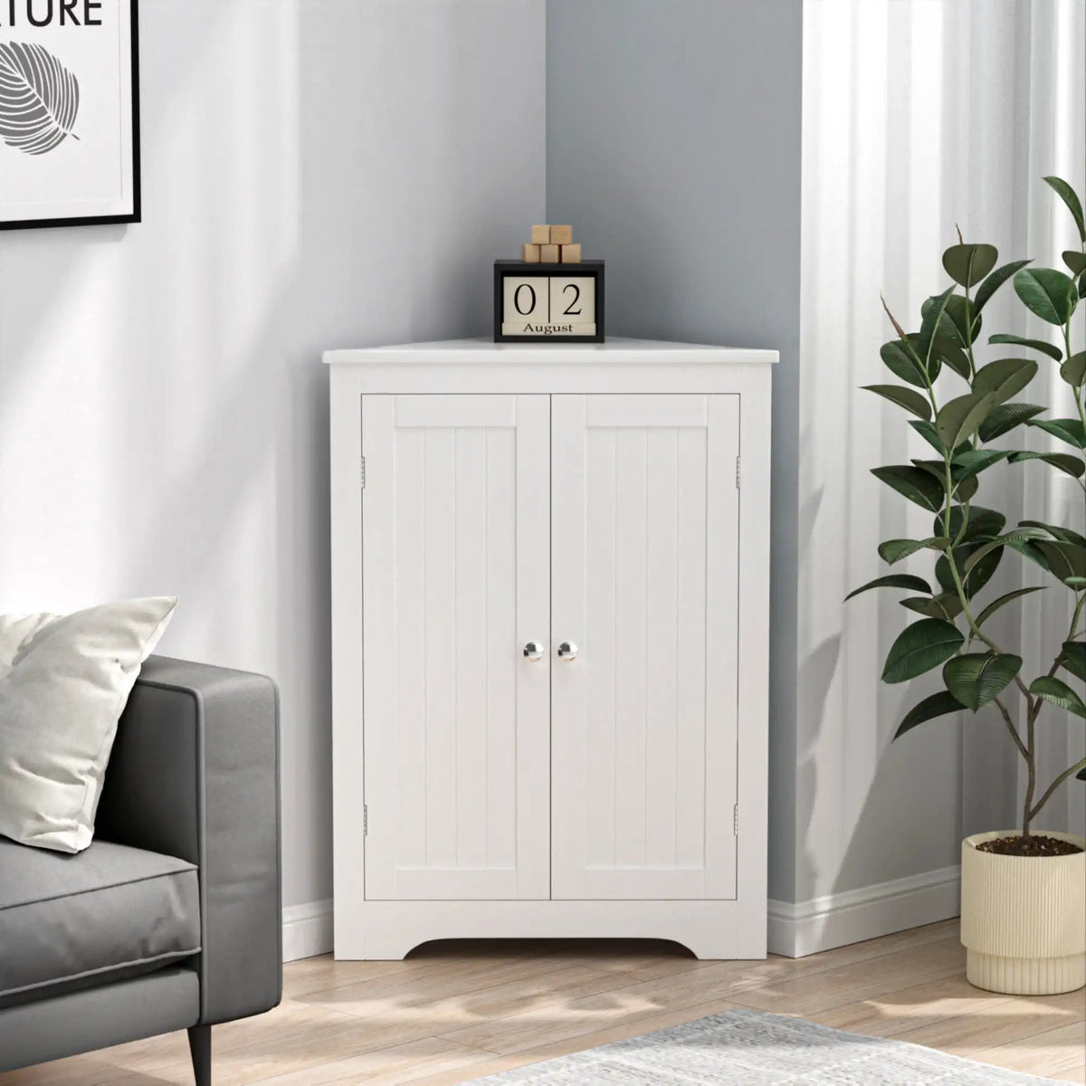 white corner side cabinet closed and positioned in a living room corner next to a gray sofa and leafy houseplant